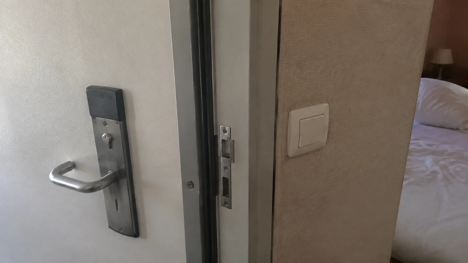 Partially open connecting door beside a cruise cabin bed