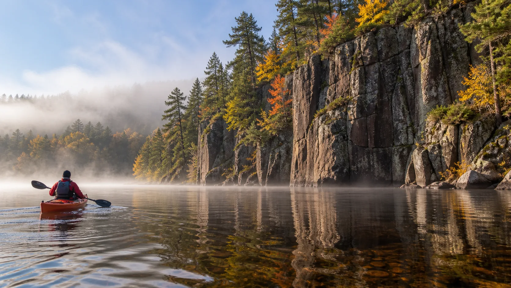 Red kayak below basalt cliffs on the St. Croix River in autumn