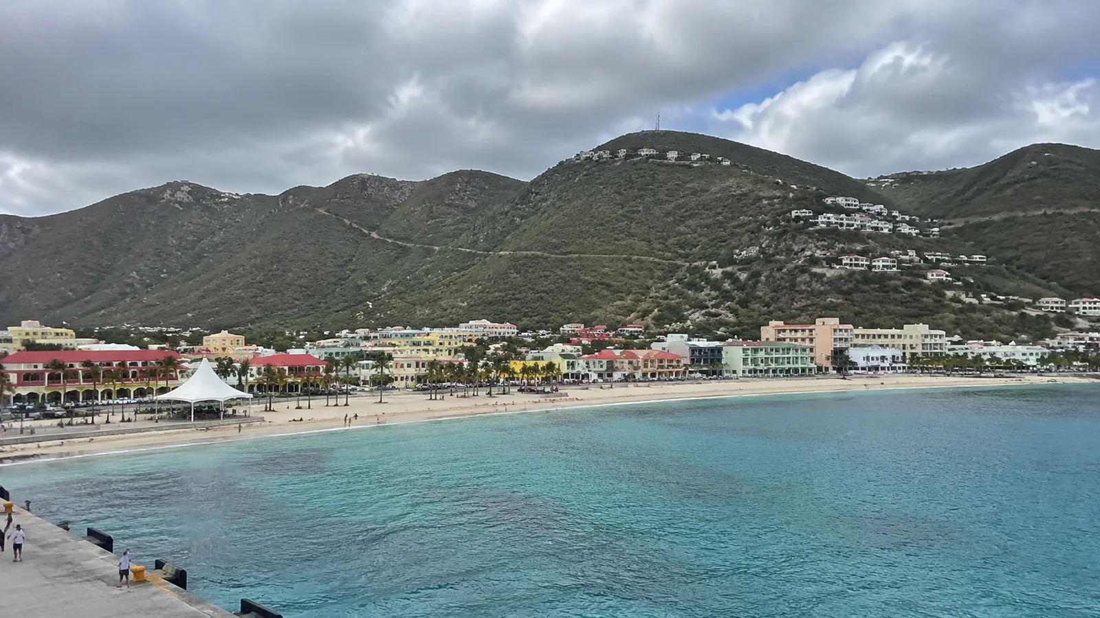 Harbor town and turquoise bay beneath green hills