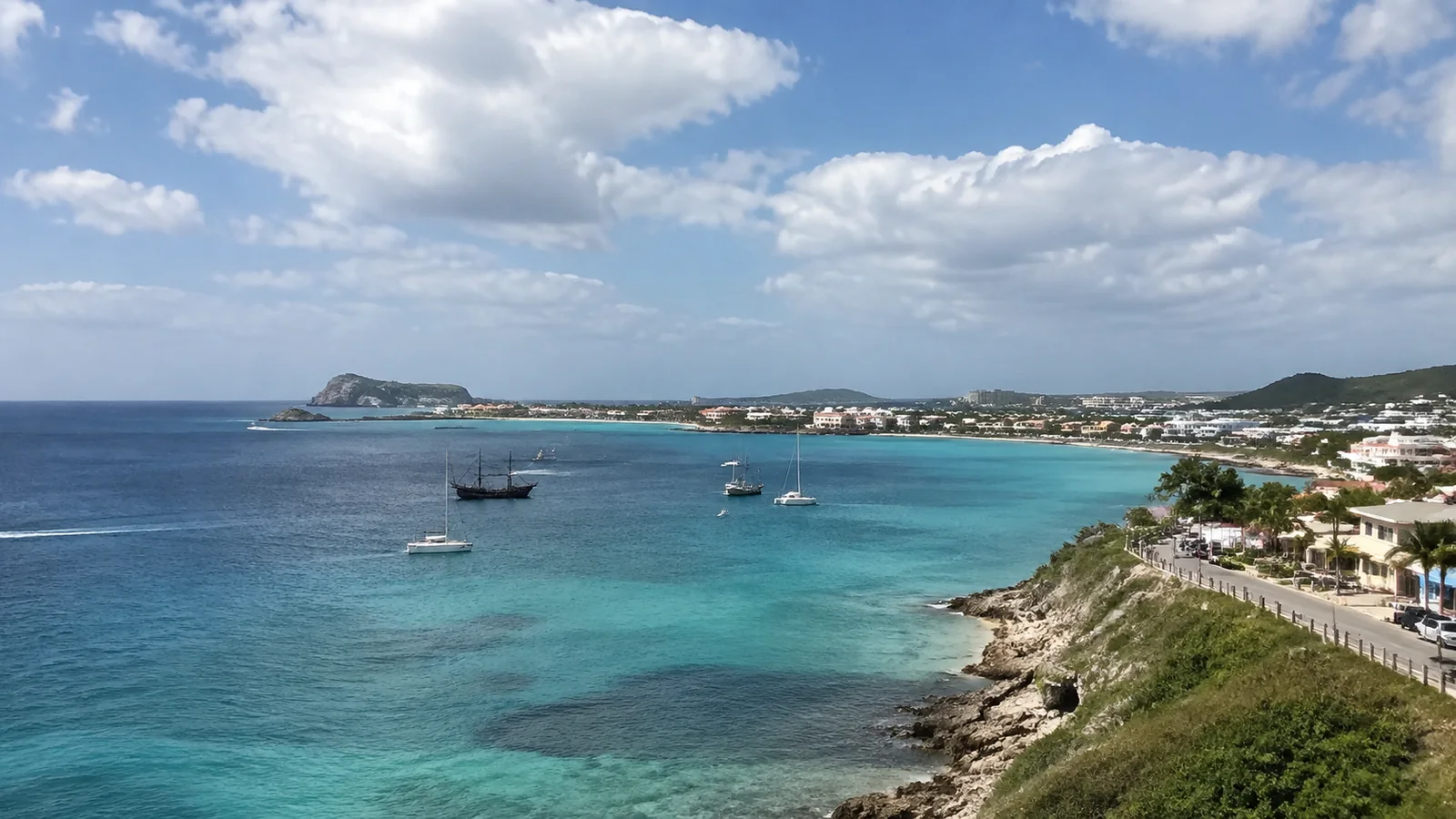 Turquoise coastline and harbor with hills in the distance