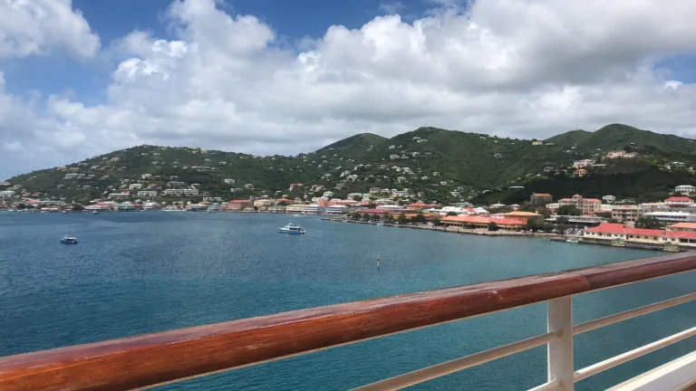 Hilly harbor town viewed over a cruise ship railing