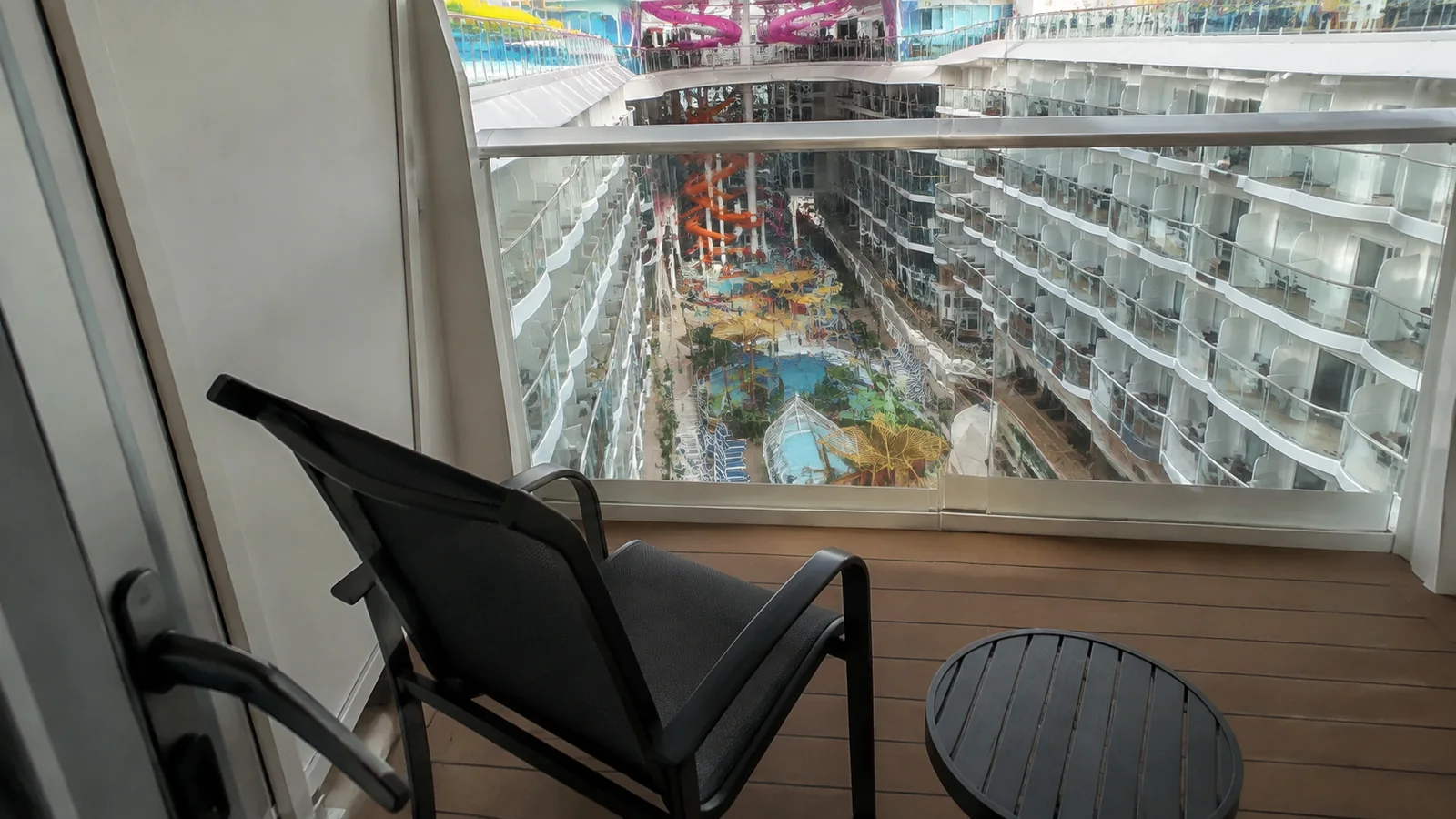 Balcony chair overlooks a landscaped central area between rows of ship balconies.