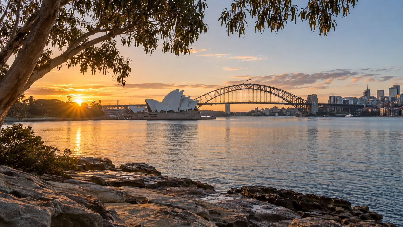 Sydney Opera House and Harbour Bridge across the harbor at sunrise