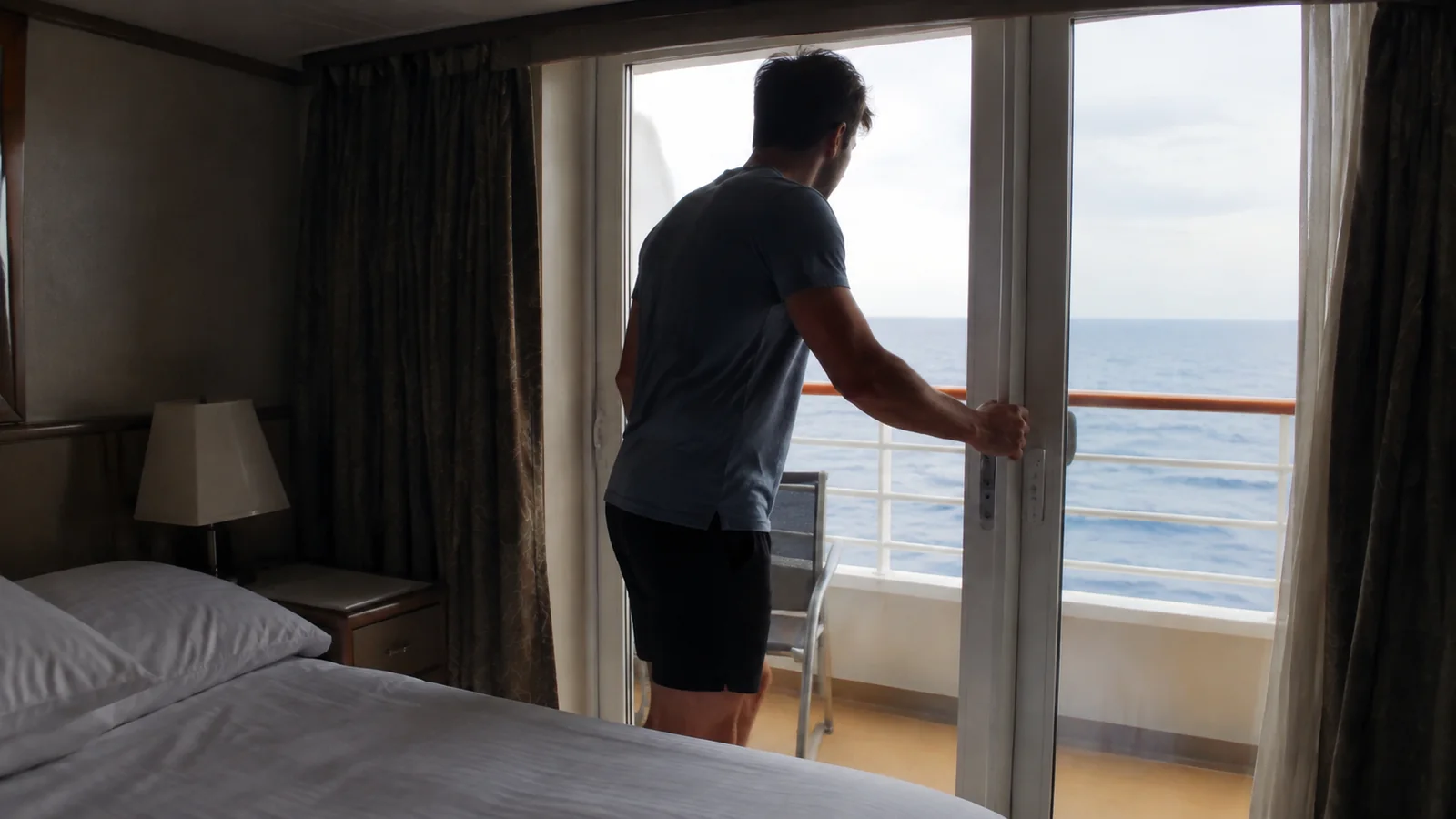Passenger opening a cabin balcony door.