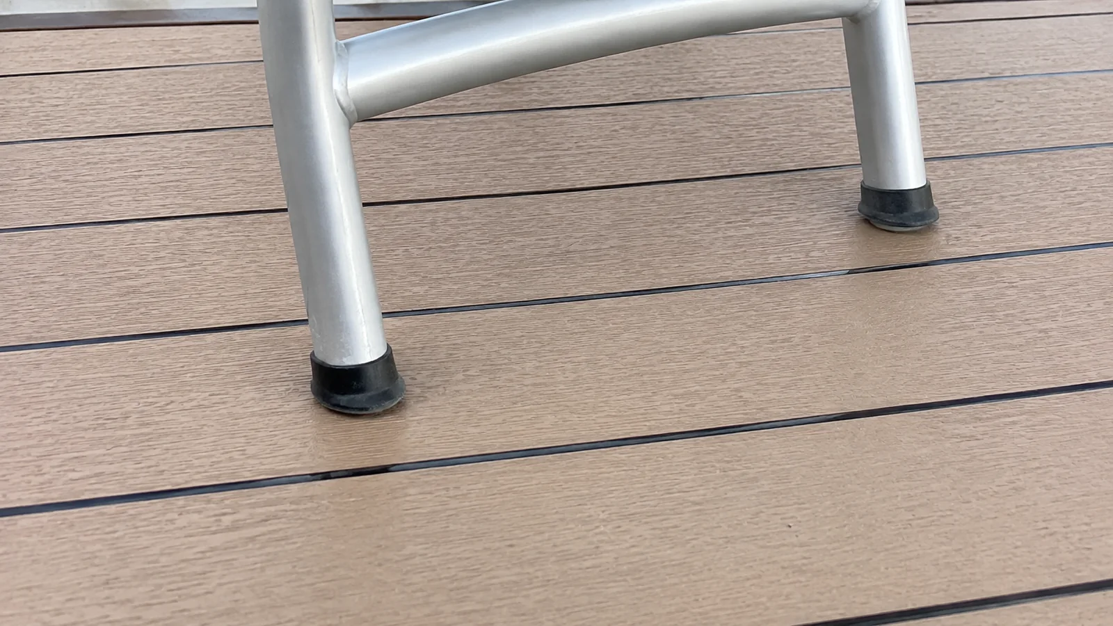 Rubber feet on a chair standing on composite deck boards.