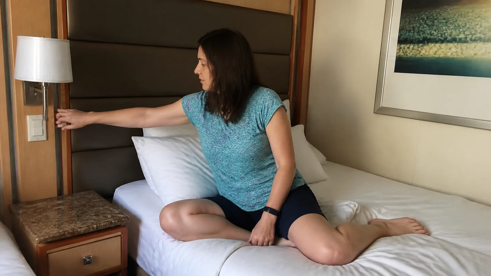 Passenger testing the bedside light while seated on a cabin bed.