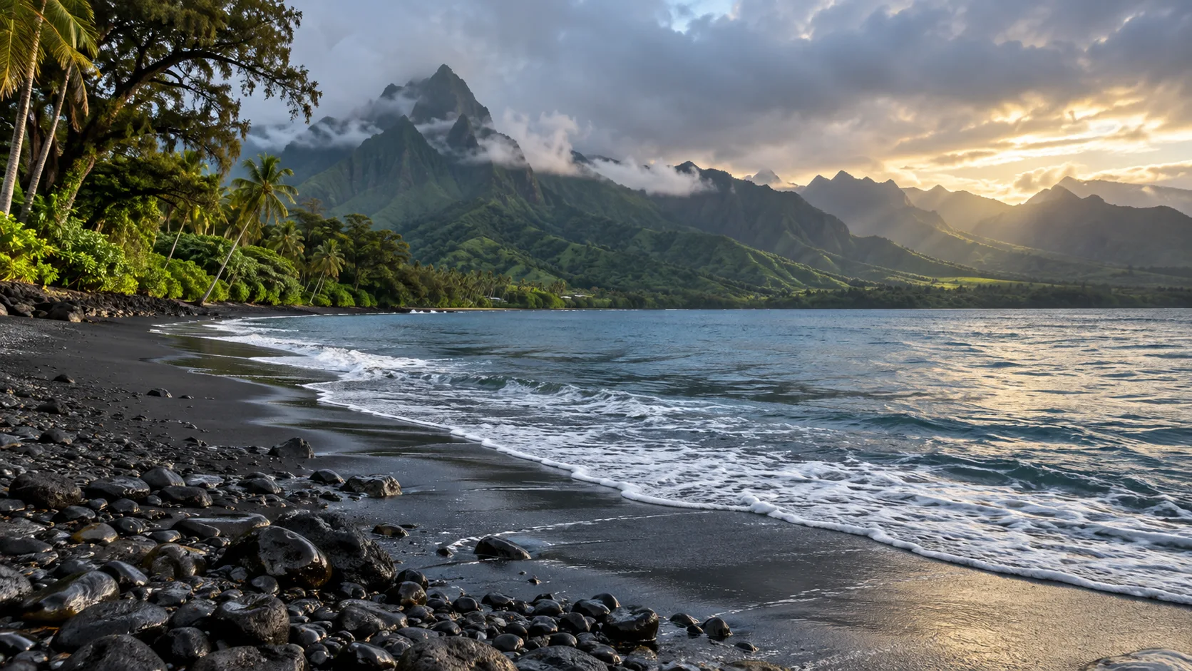 Tahiti's black-sand Pointe Venus shoreline beneath cloud-wrapped green volcanic mountains after rain