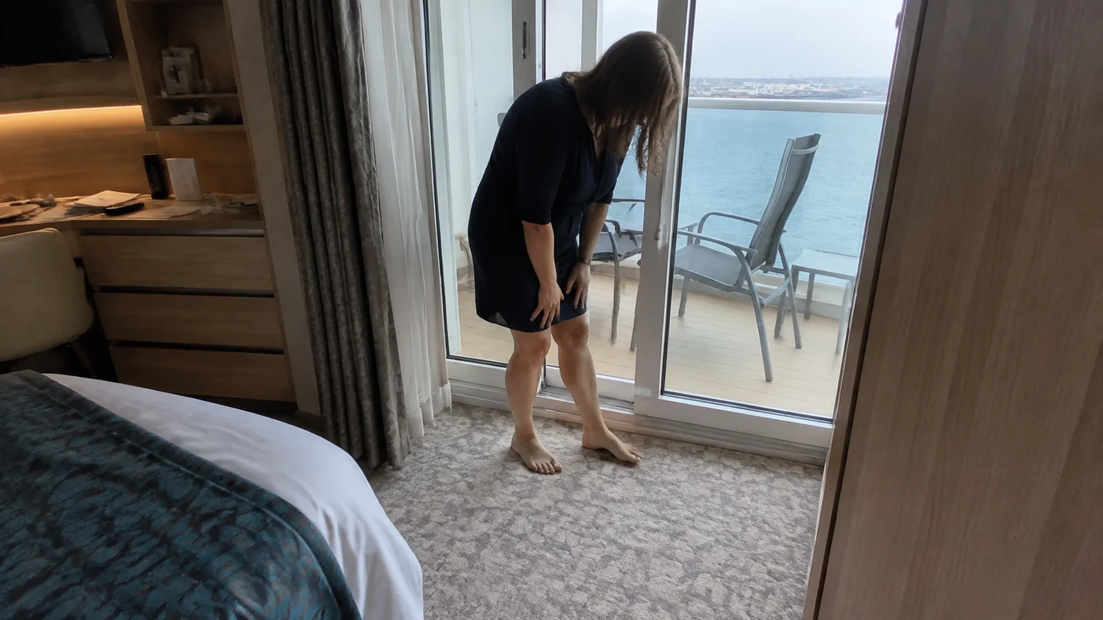 Passenger checking the threshold of a cabin balcony door.