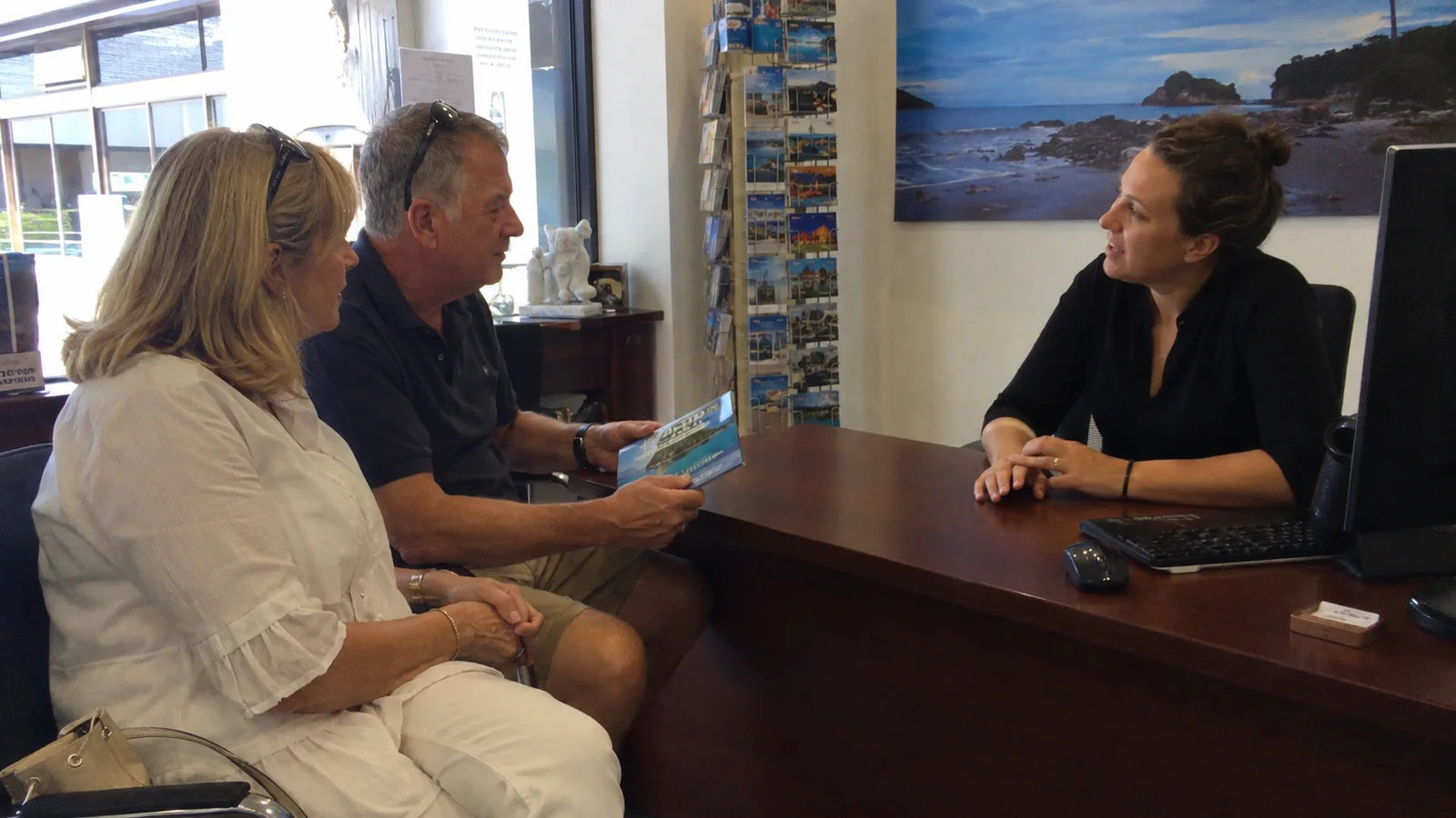 Couple discussing a cruise with a travel agent.