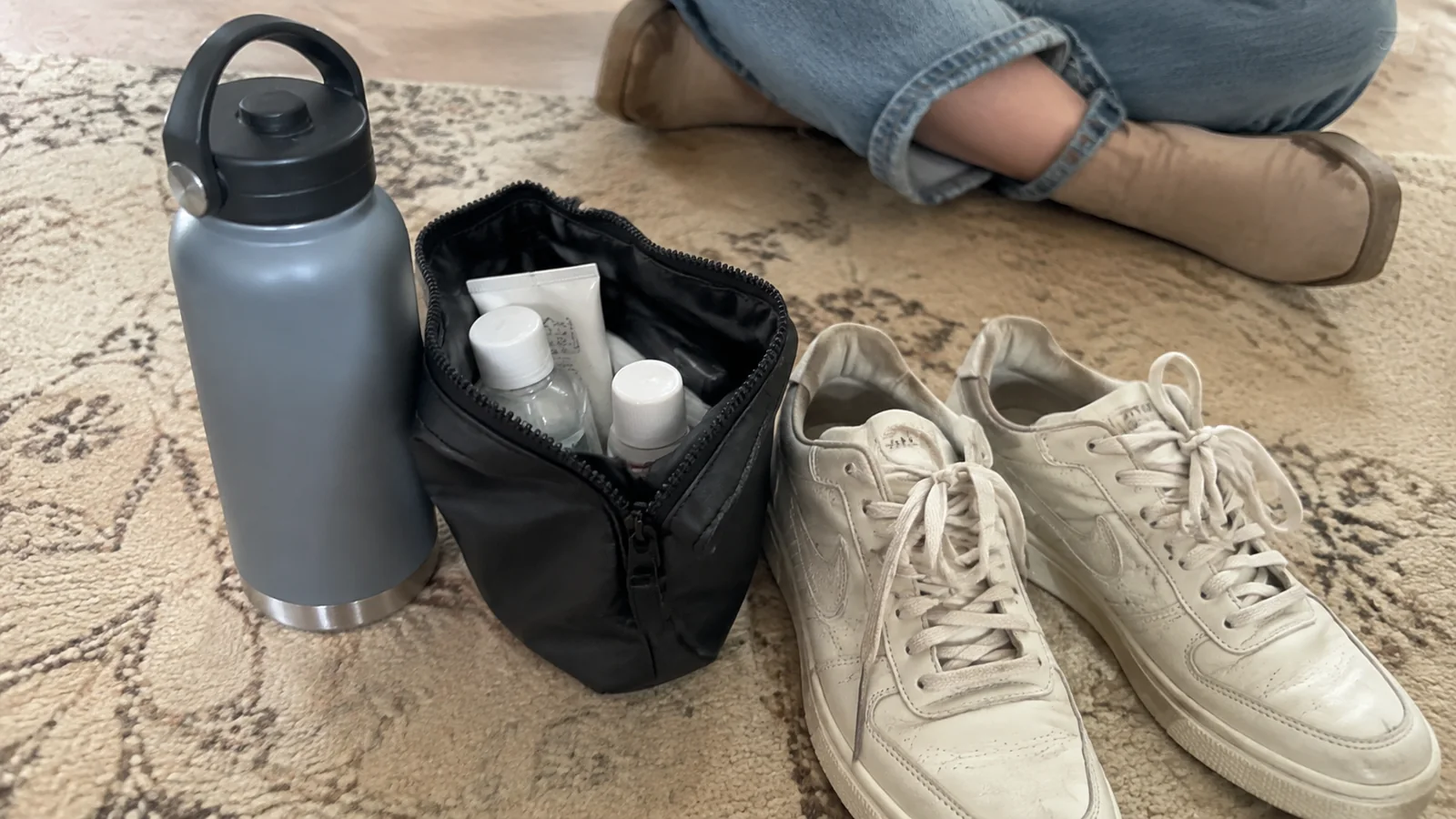 Water bottle, toiletry pouch and sneakers ready for packing.