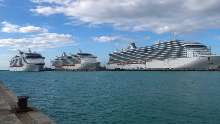 Three large cruise ships lined up across a harbor.