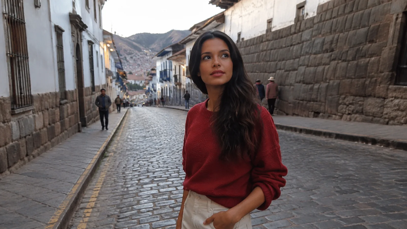 Woman walks beside an old stone wall on a cobbled city street.