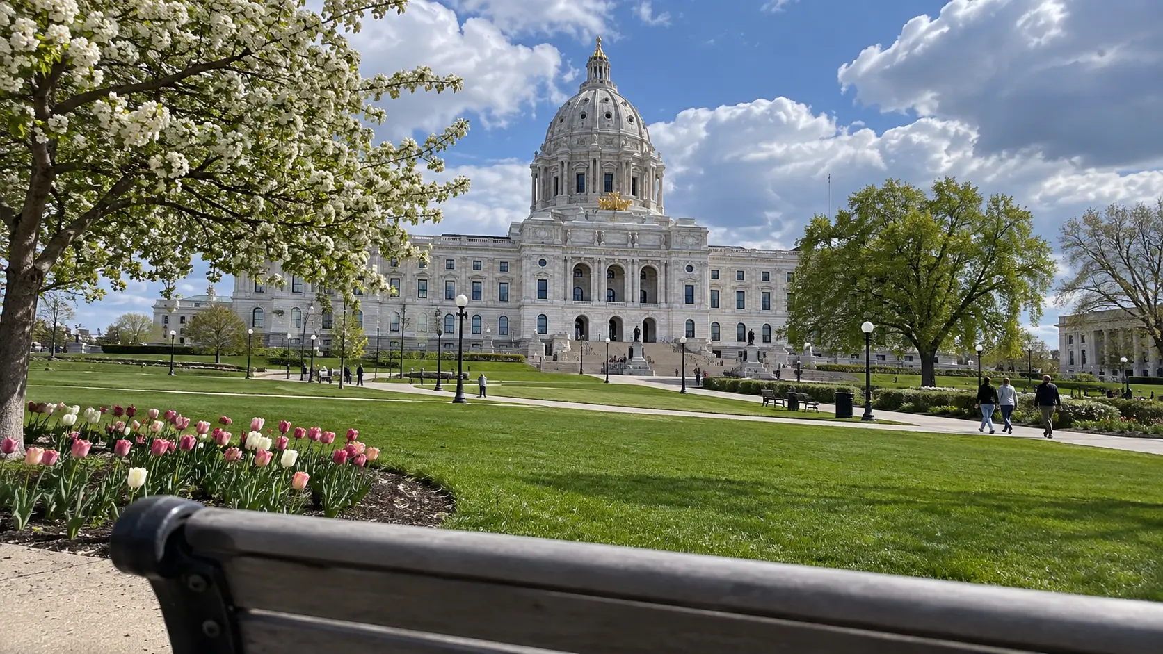 The marble Minnesota State Capitol and its gilded dome beneath a blue sky.
