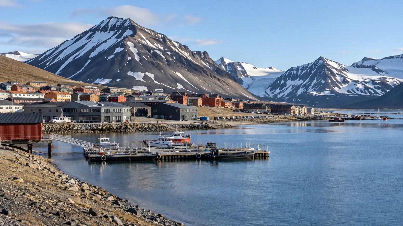 Longyearbyen's colorful Arctic settlement and harbor beneath snowy Svalbard mountains