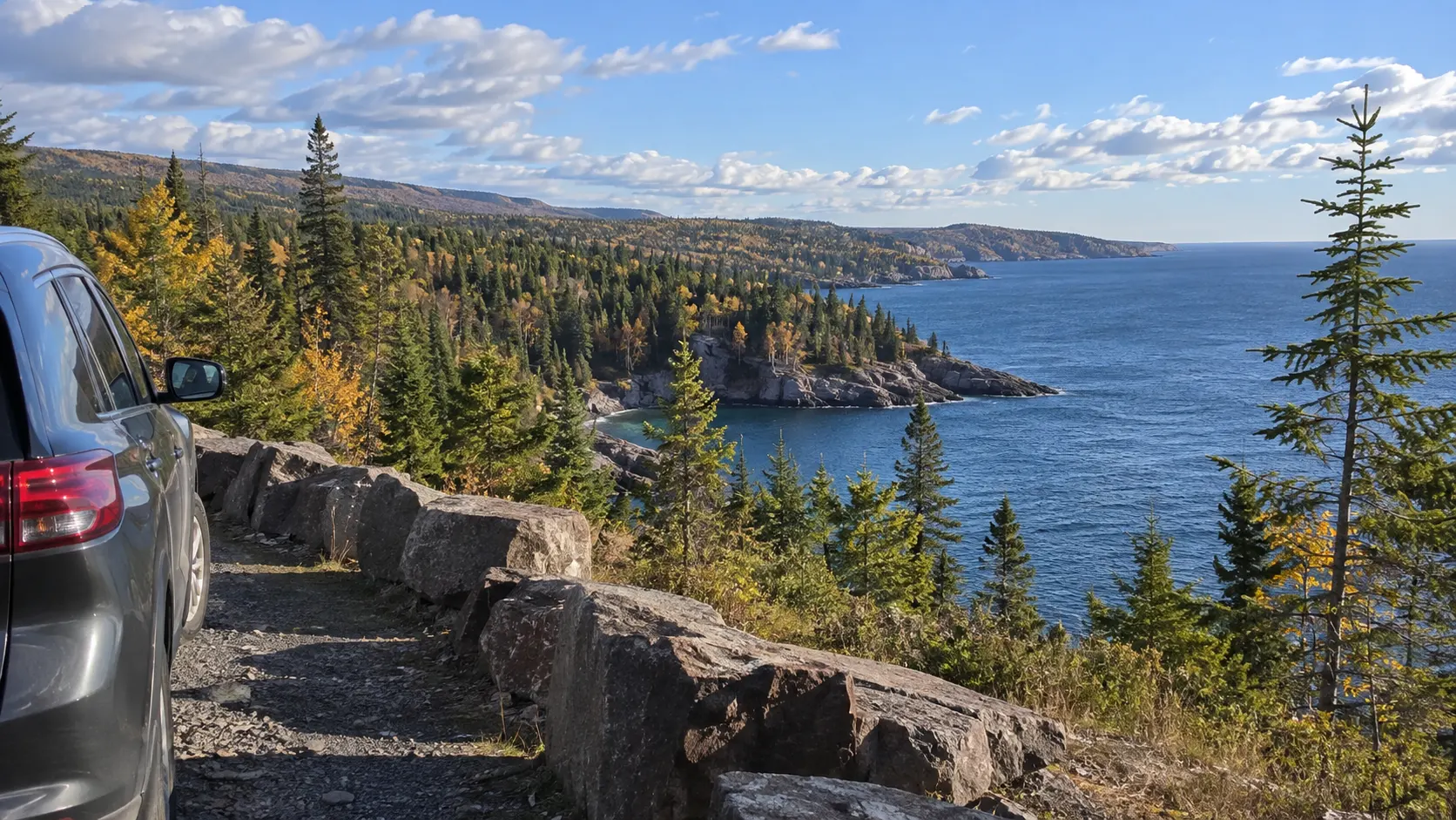 Car overlooking the rocky Lake Superior shoreline on an Upper Midwest road trip.