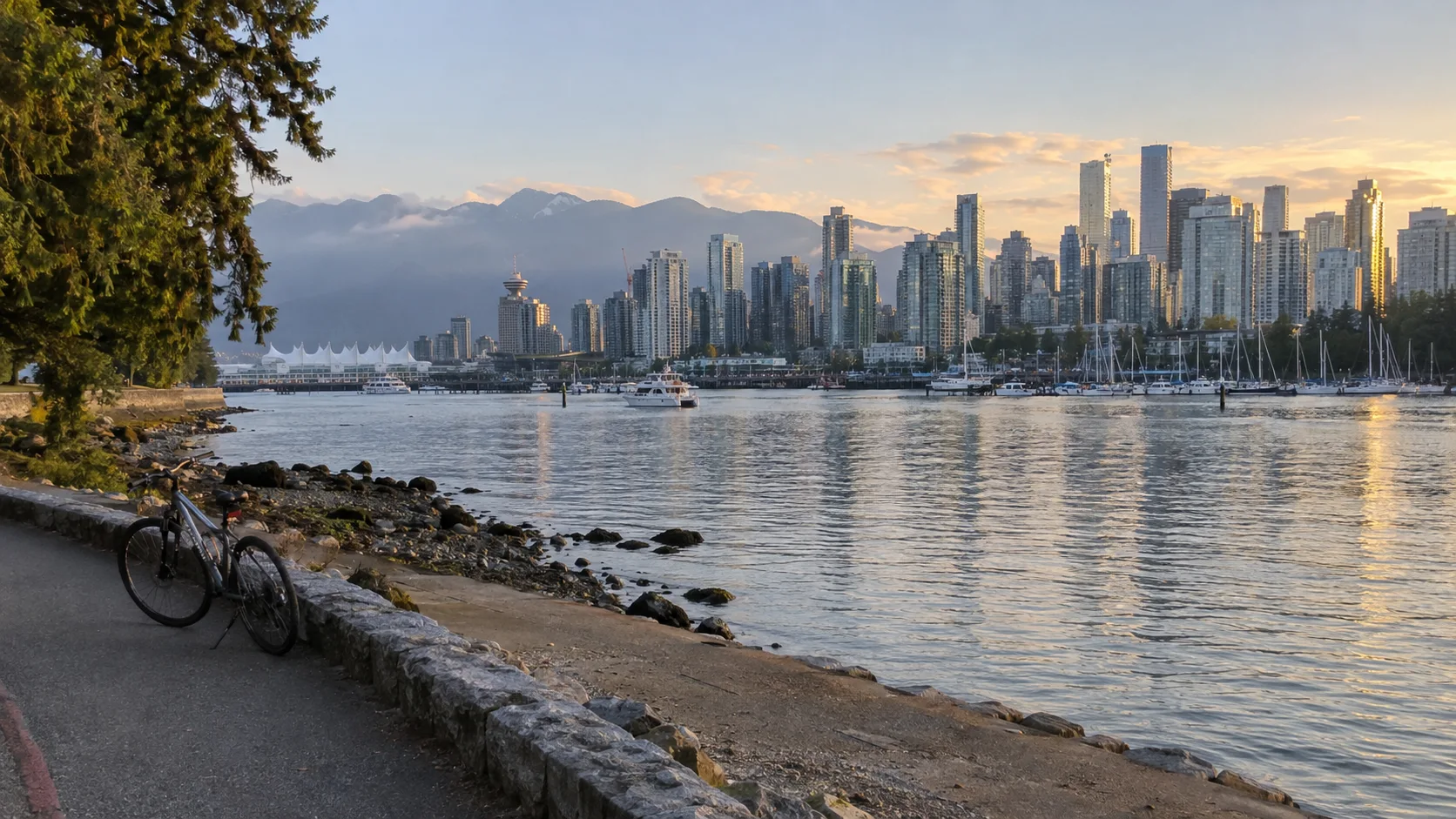 Bicycle beside the Stanley Park seawall overlooking Vancouver's harbor skyline and mountains.