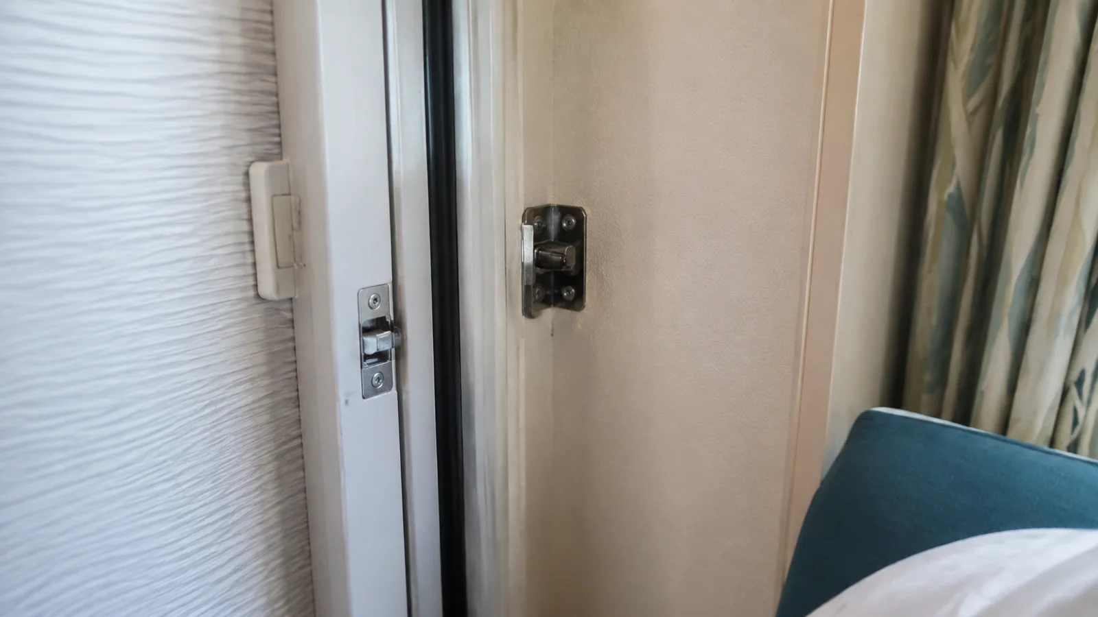 Connecting door beside a blue sofa inside a cruise cabin