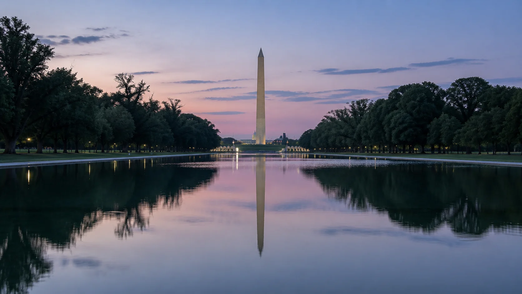 Washington Monument reflected in the Reflecting Pool beneath a pastel evening sky.
