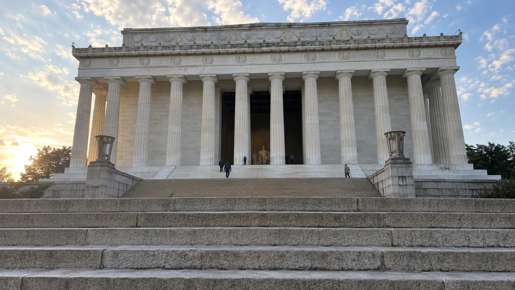 Broad stone steps leading to the columned Lincoln Memorial near sunrise.