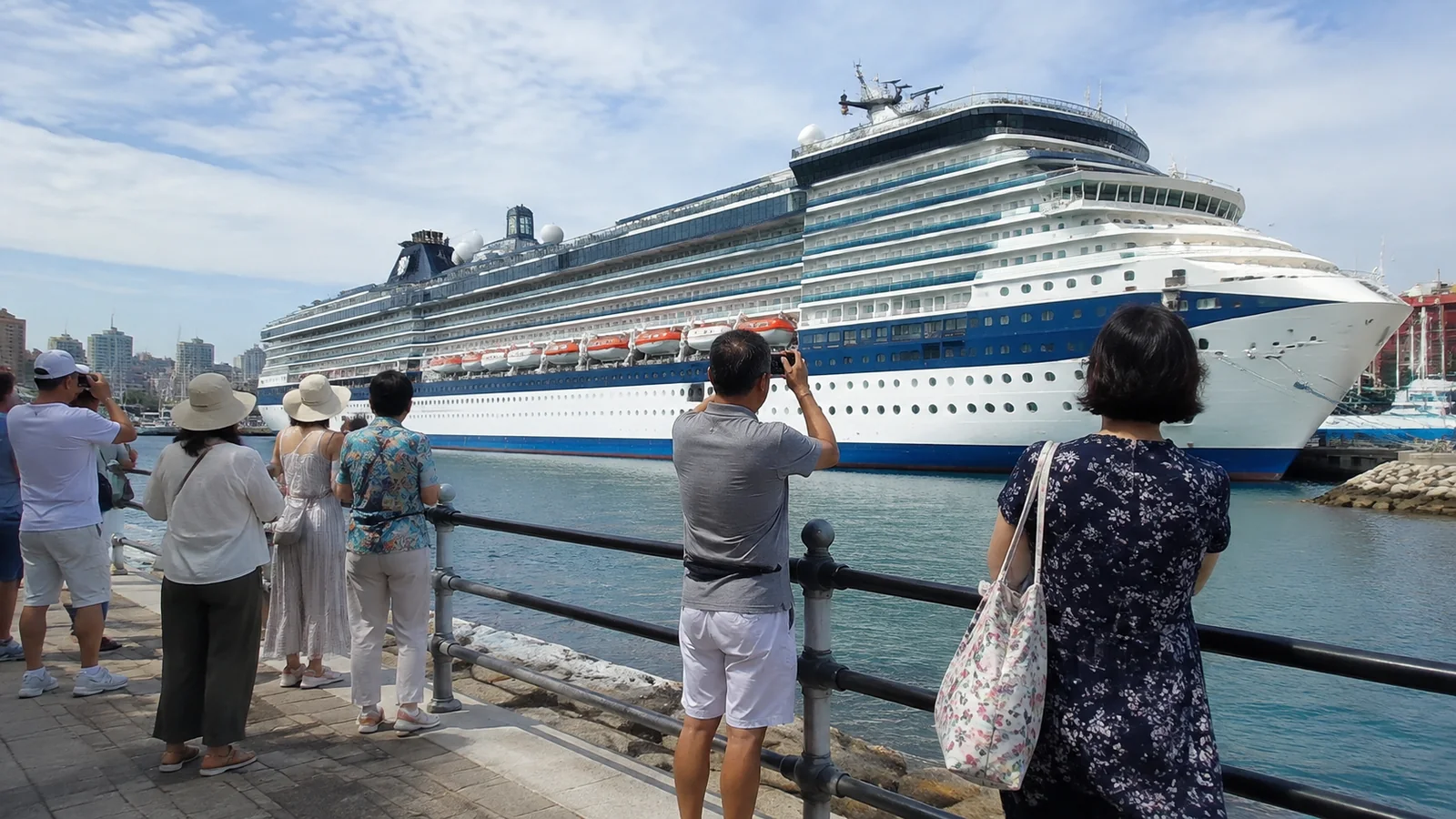Visitors photograph a large cruise ship from the dock.