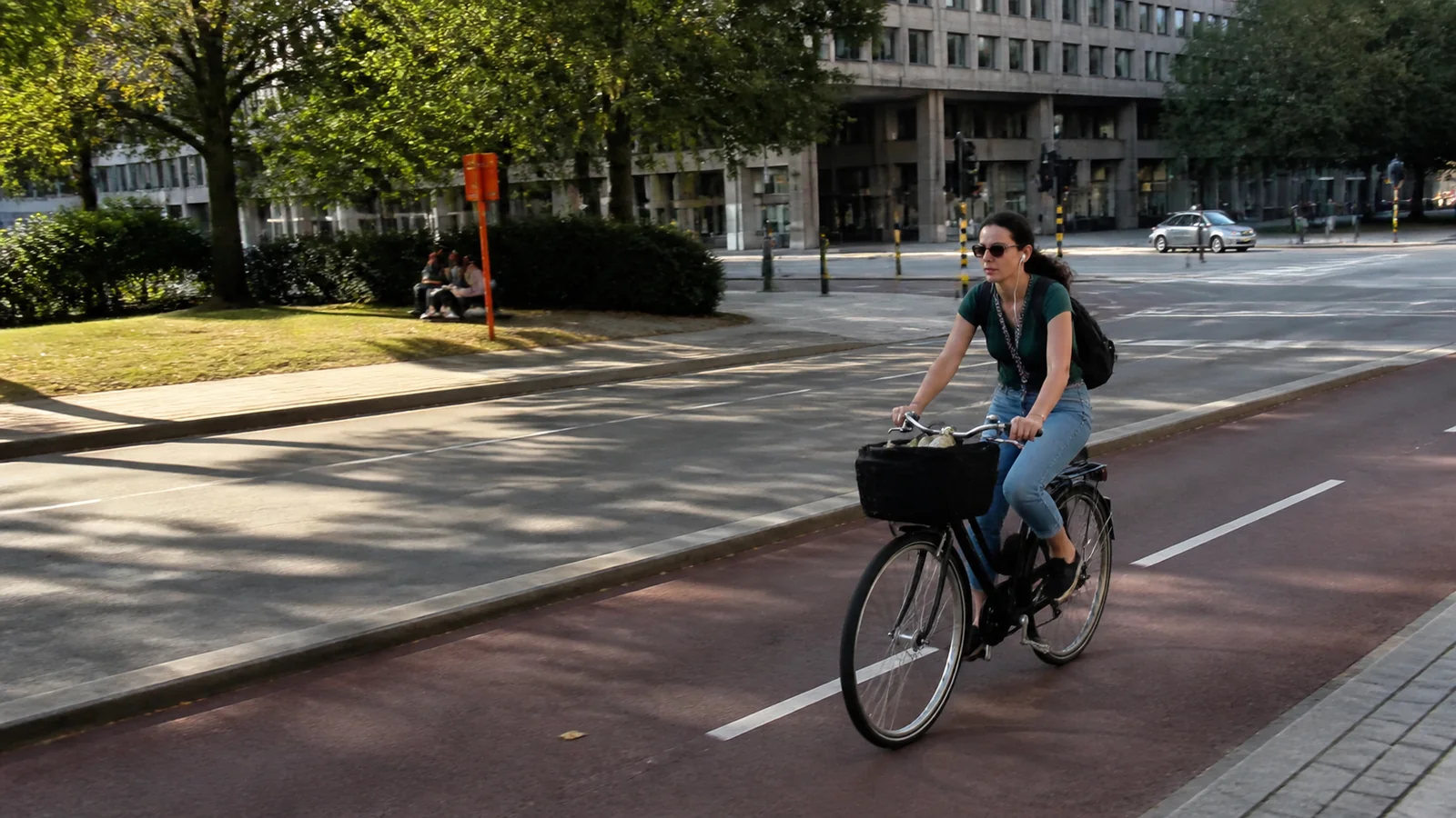 Woman cycling along a marked urban bike lane.
