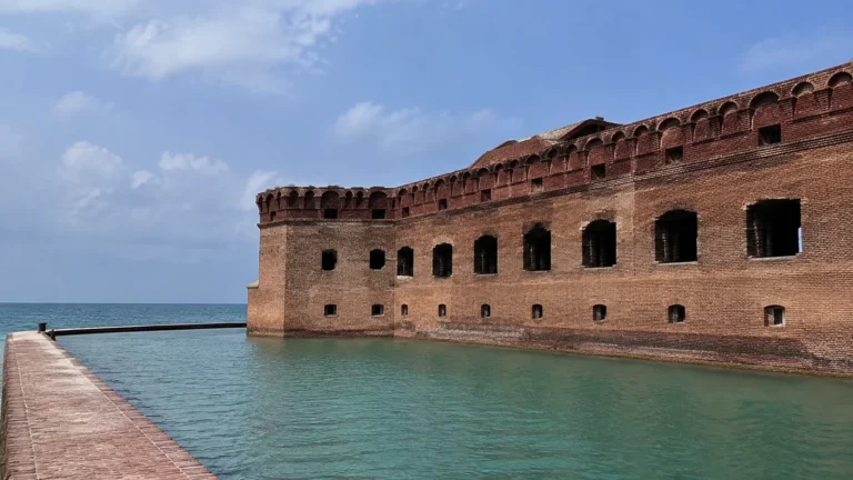 Red brick coastal fort surrounded by turquoise water