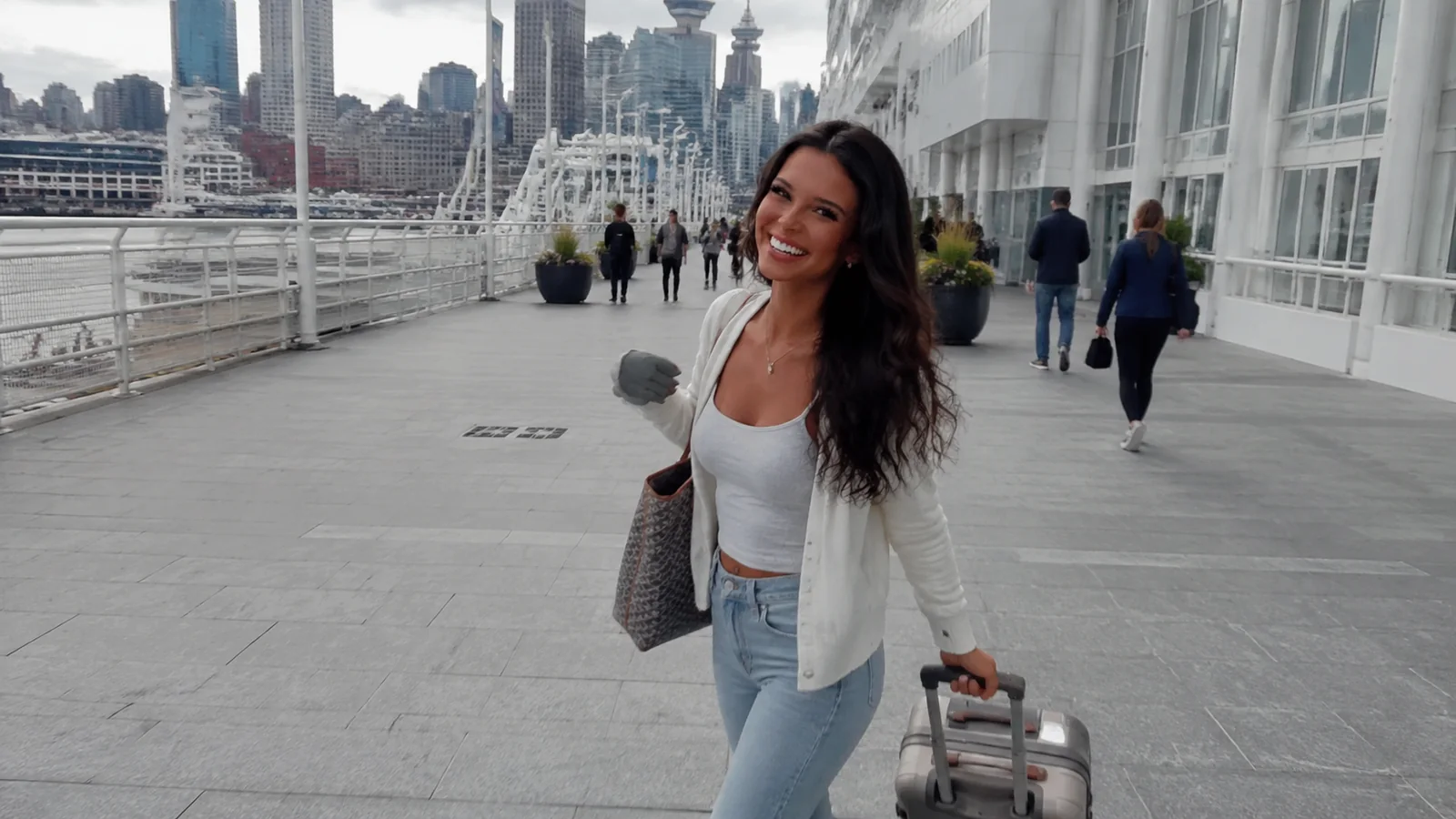 Smiling woman pulling a suitcase along a cruise terminal walkway