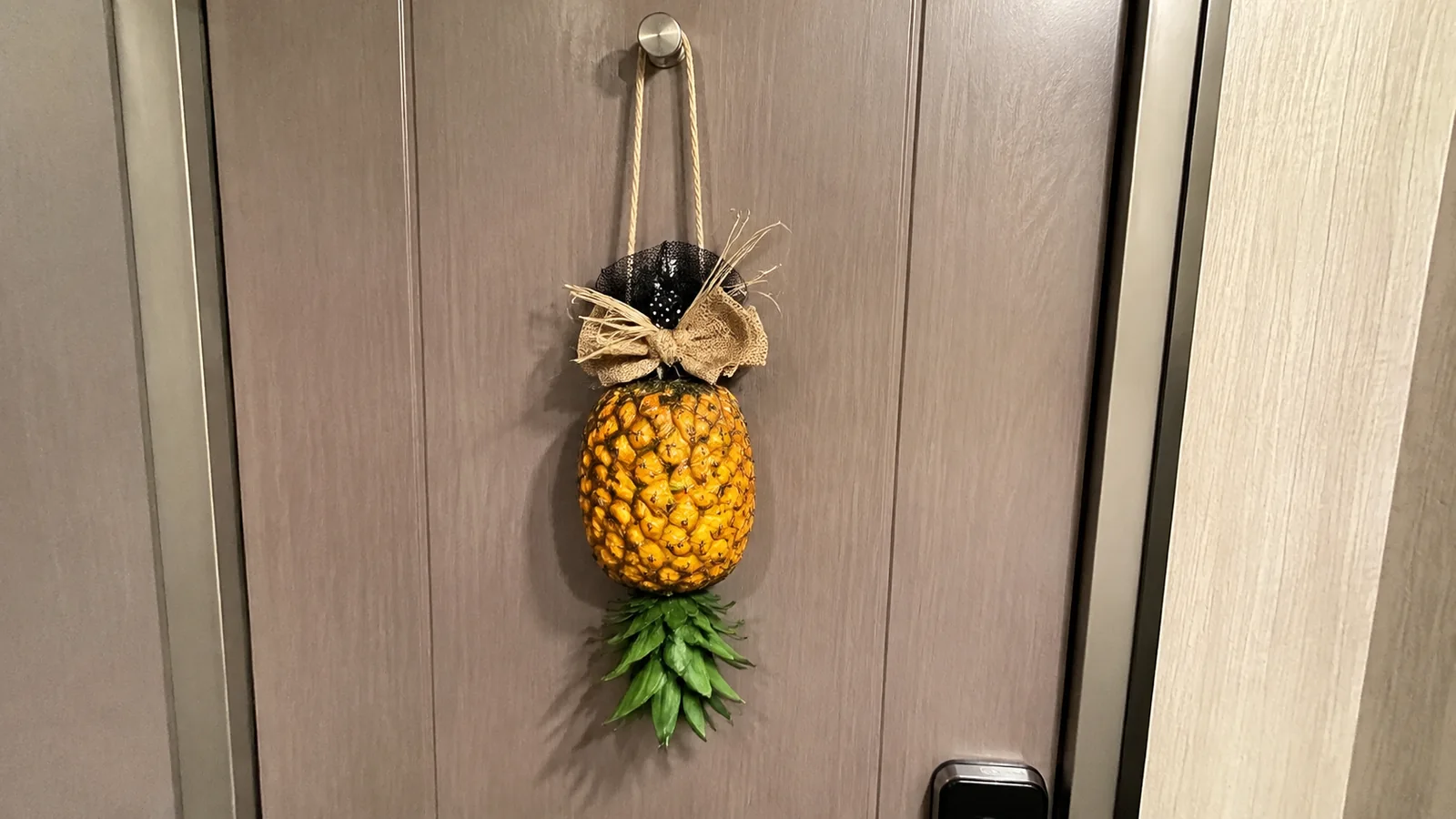 Decorative pineapple hanging upside down on a cruise cabin door