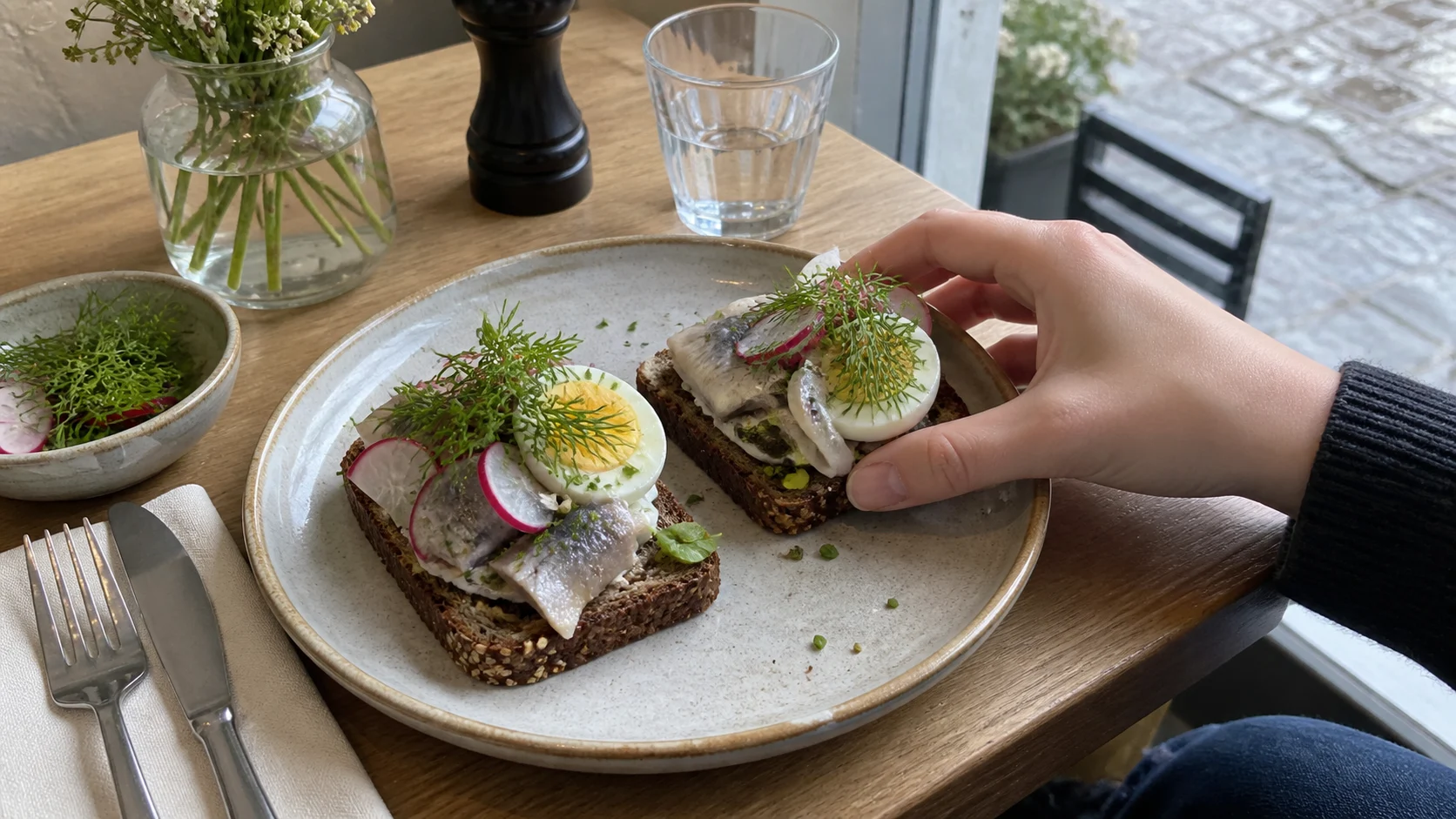 Traditional Danish smørrebrød on rye bread at a café table