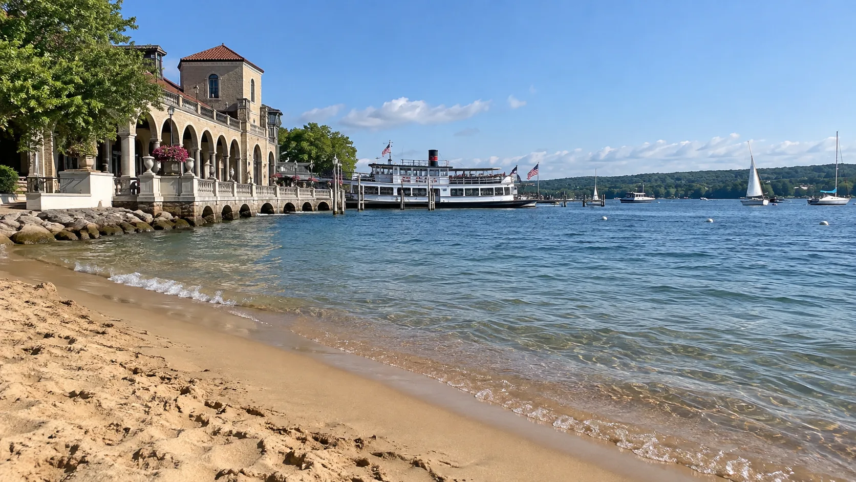 Riviera Beach overlooks Geneva Lake beside the historic Riviera building, excursion boat, and sailboats.